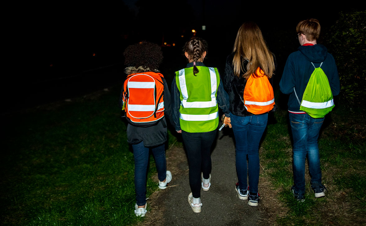 Children with bags and high vis in the dark